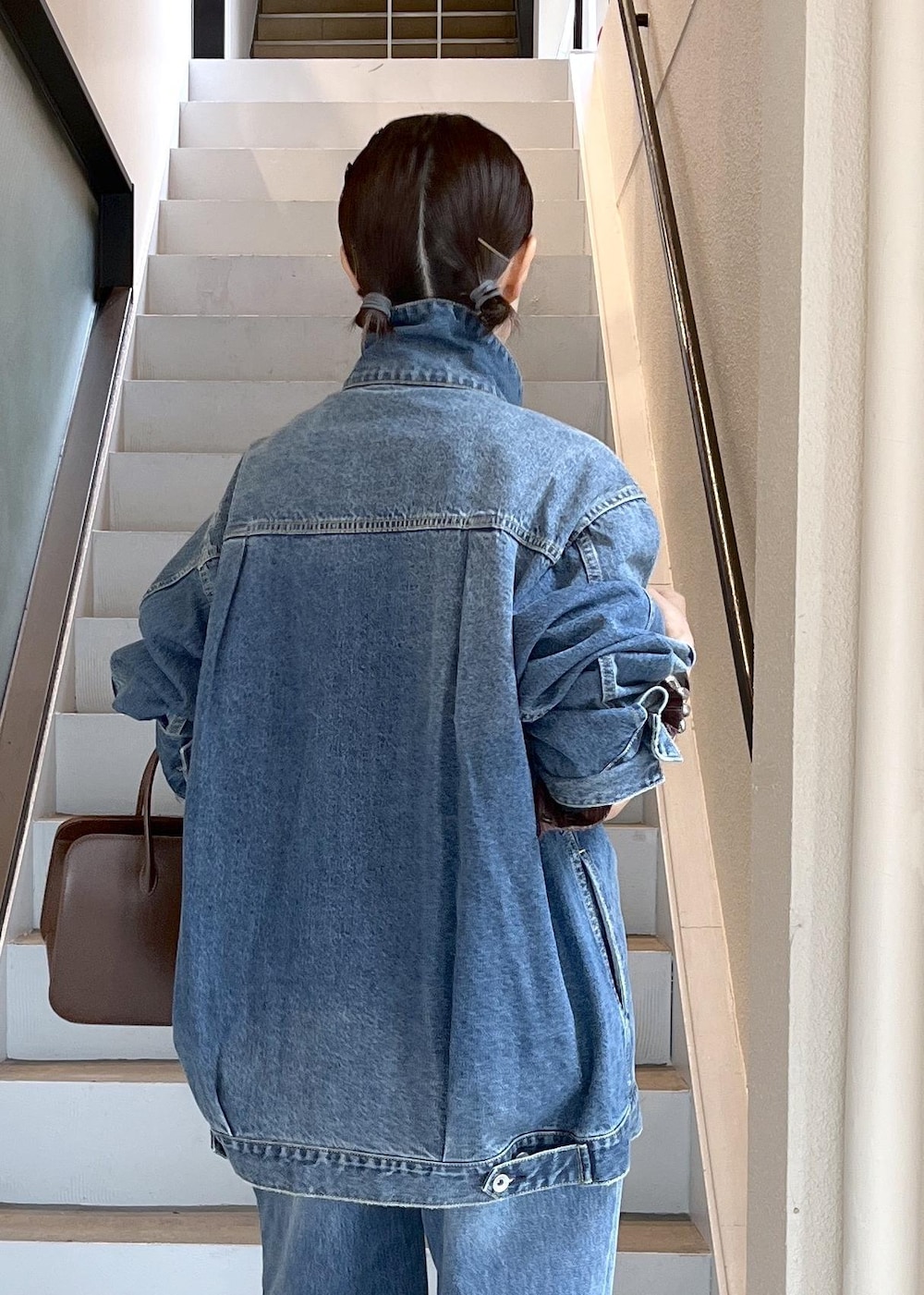 ブルー系のデニムジャケット、ブラウン系のシャツ/ブラウス、ブルー系のデニムパンツを着用したレディースの夏コーディネートの4枚目の写真