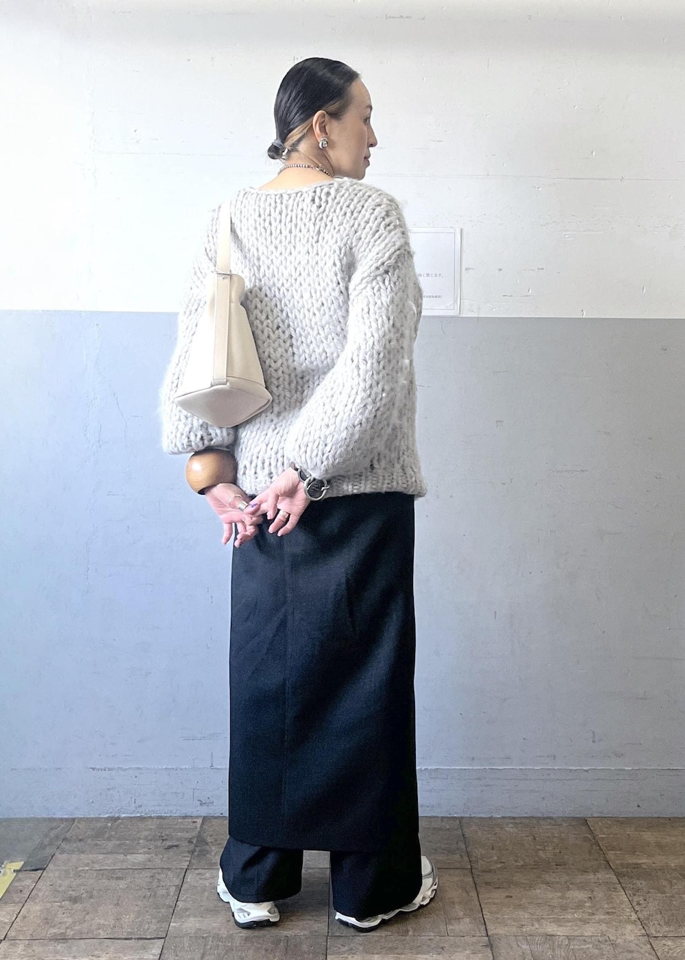 ブラック系のスカート、ホワイト系のショルダーバッグ、ホワイト系のスニーカーを着用したレディースの冬コーディネートの6枚目の写真