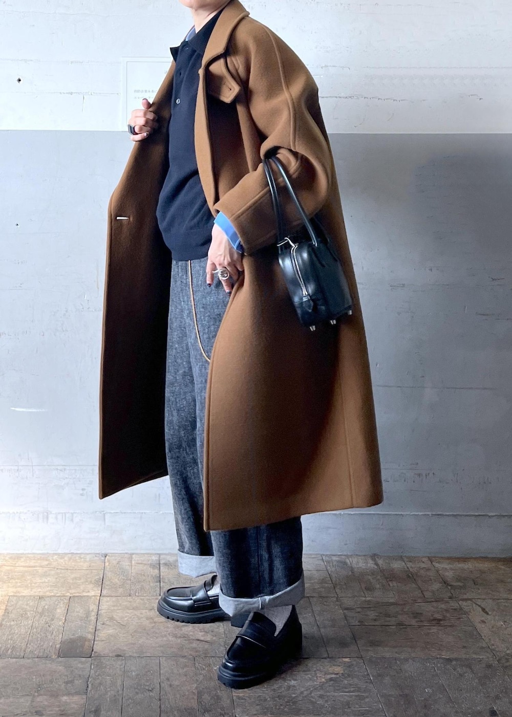 イエロー系のステンカラーコートを着用したレディースの秋コーディネートの2枚目の写真