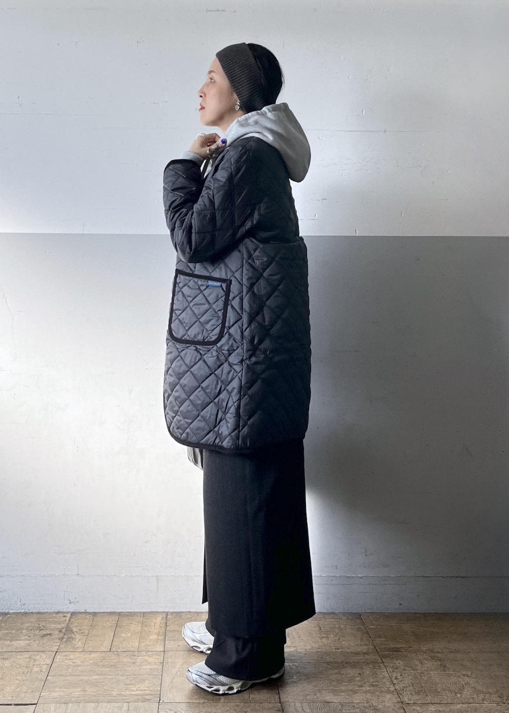 ブラック系のショルダーバッグ、ブラック系のスカート、ホワイト系のスニーカーを着用したレディースの冬コーディネートの3枚目の写真