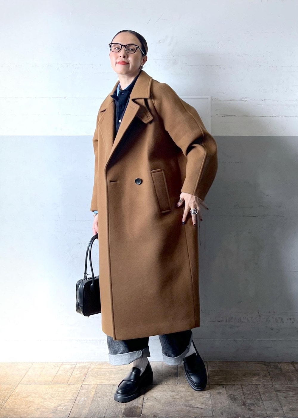 イエロー系のステンカラーコートを着用したレディースの秋コーディネートの7枚目の写真