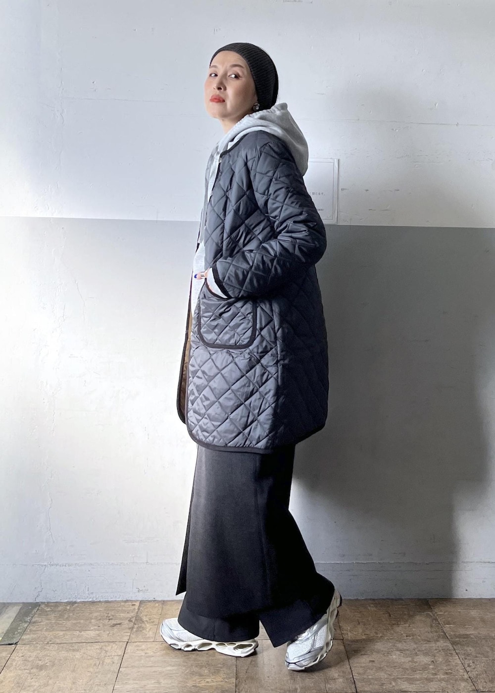 ブラック系のショルダーバッグ、ブラック系のスカート、ホワイト系のスニーカーを着用したレディースの冬コーディネートの4枚目の写真