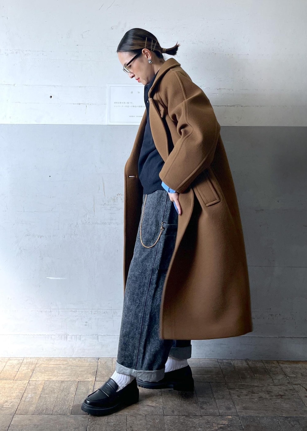 イエロー系のステンカラーコートを着用したレディースの秋コーディネートの3枚目の写真