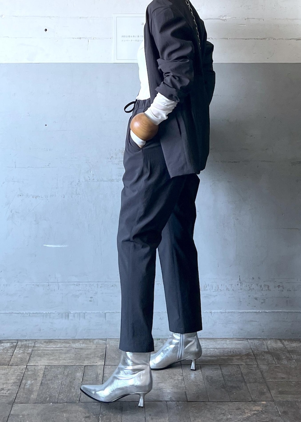 ブラック系のハンドバッグ、ブラック系のセットアップ、シルバー系のブーツを着用したレディースの秋コーディネートの4枚目の写真