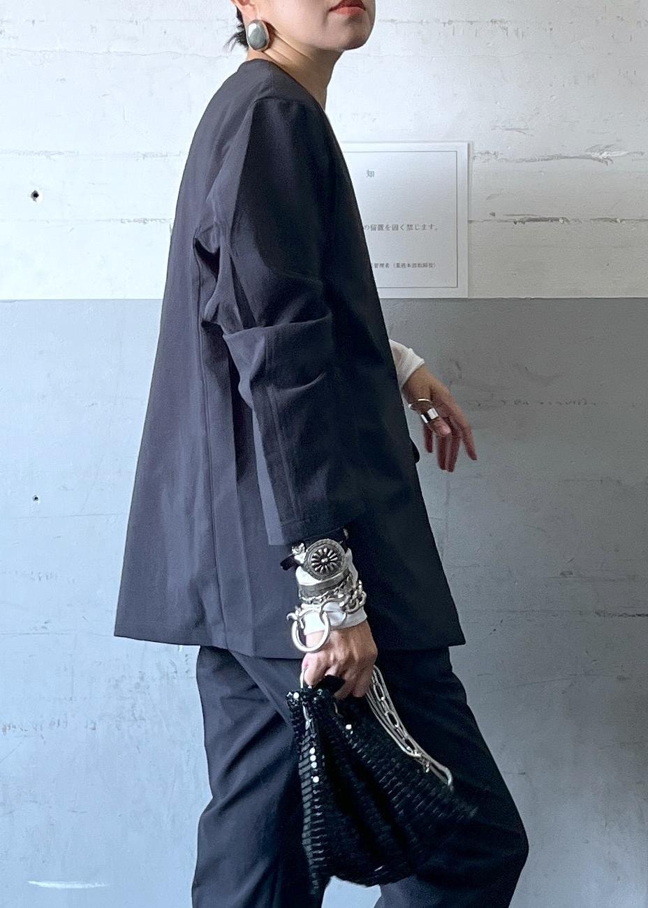 ブラック系のハンドバッグ、ブラック系のセットアップ、シルバー系のブーツを着用したレディースの秋コーディネートの7枚目の写真