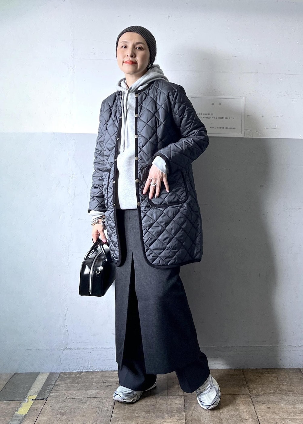 ブラック系のショルダーバッグ、ブラック系のスカート、ホワイト系のスニーカーを着用したレディースの冬コーディネートの9枚目の写真