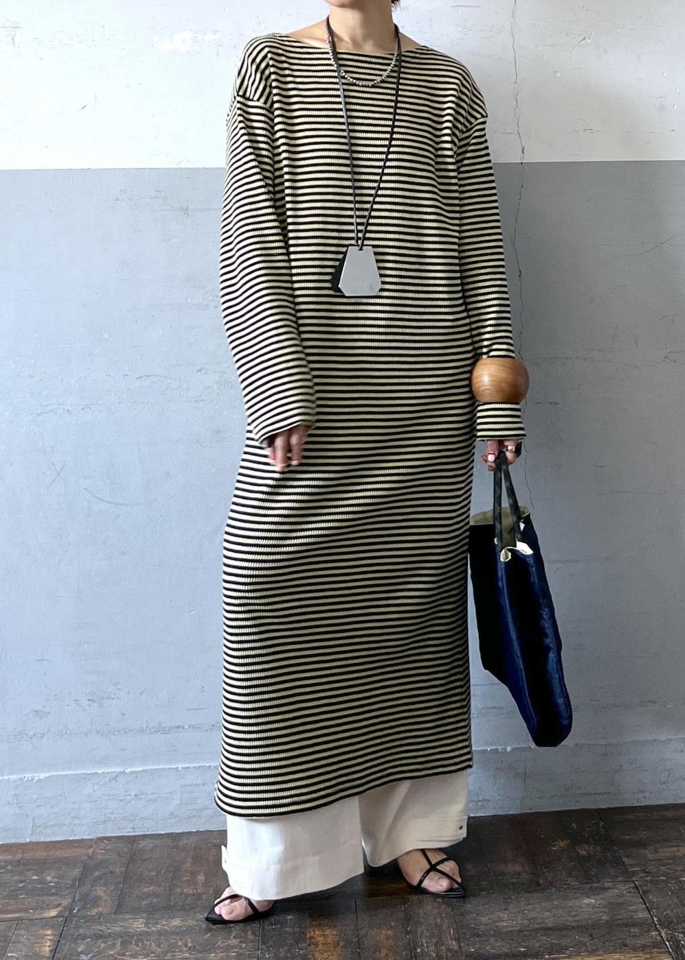 ブラック系のサンダル、グリーン系のワンピース、ホワイト系のその他パンツを着用したレディースの春コーディネートの2枚目の写真