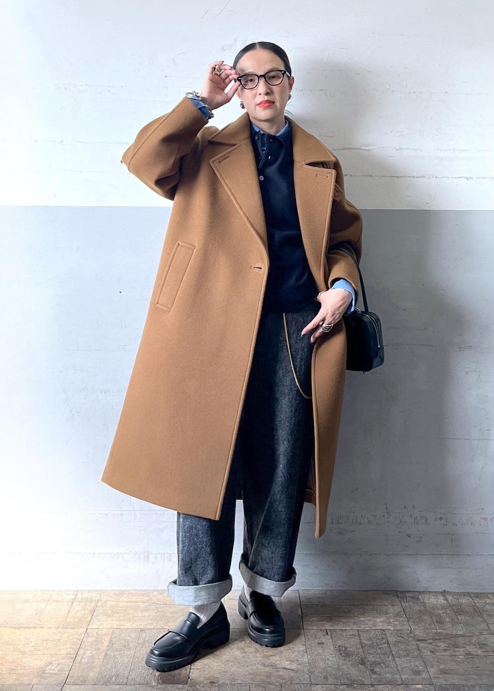 イエロー系のステンカラーコートを着用したレディースの秋コーディネートの6枚目の写真