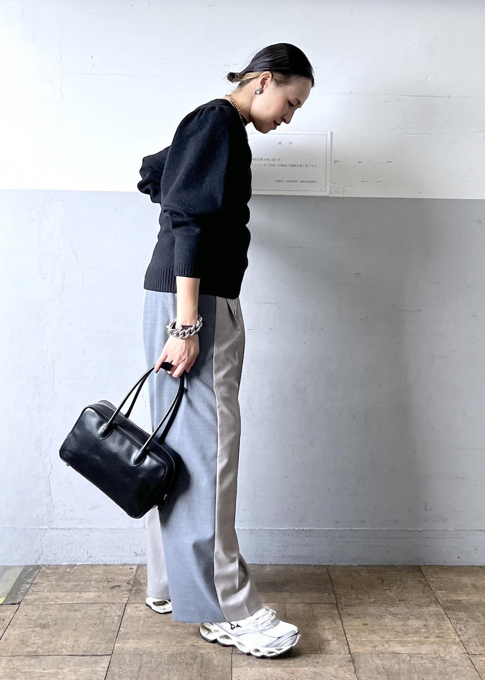 グレー系のその他パンツ、ブラック系のニット/セーター、ホワイト系のスニーカーを着用したレディースの冬コーディネートの3枚目の写真