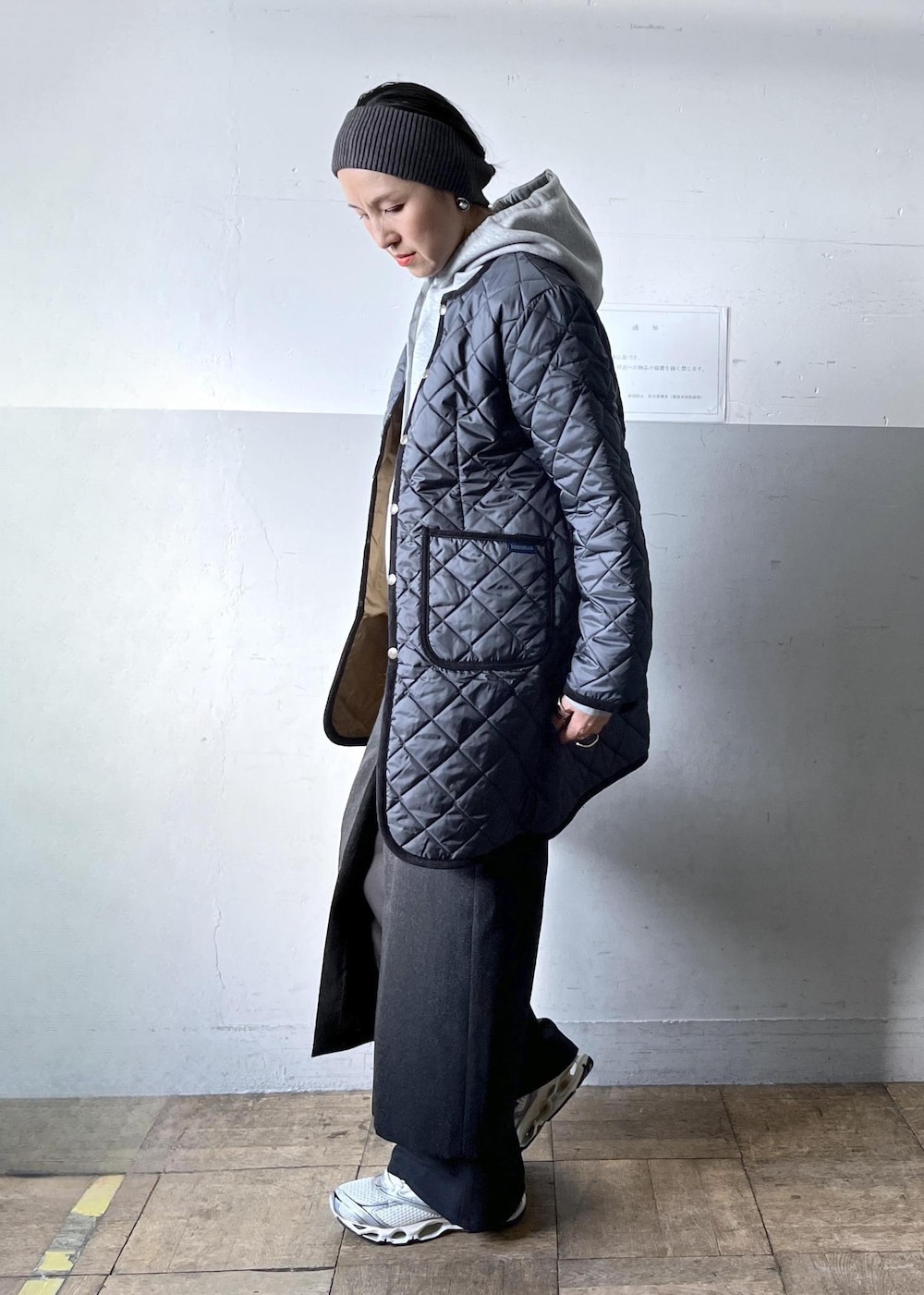 ブラック系のショルダーバッグ、ブラック系のスカート、ホワイト系のスニーカーを着用したレディースの冬コーディネートの2枚目の写真