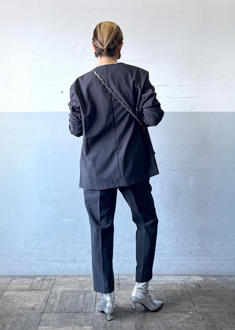 ブラック系のハンドバッグ、ブラック系のセットアップ、シルバー系のブーツを着用したレディースの秋コーディネートの9枚目の写真