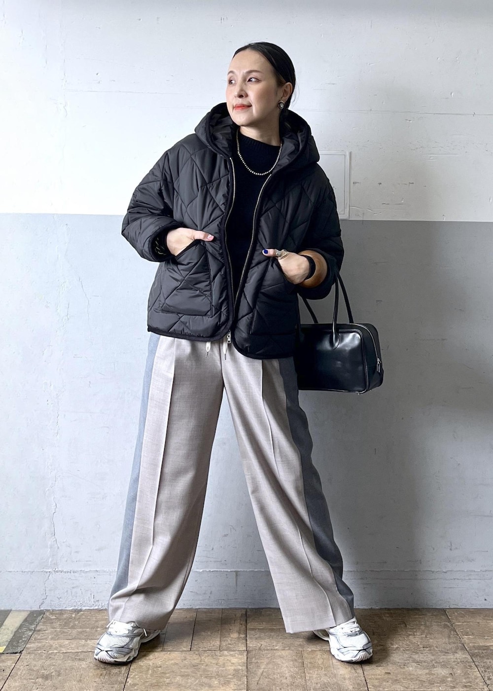 グレー系のその他パンツ、ブラック系のニット/セーター、ホワイト系のスニーカーを着用したレディースの冬コーディネートの4枚目の写真