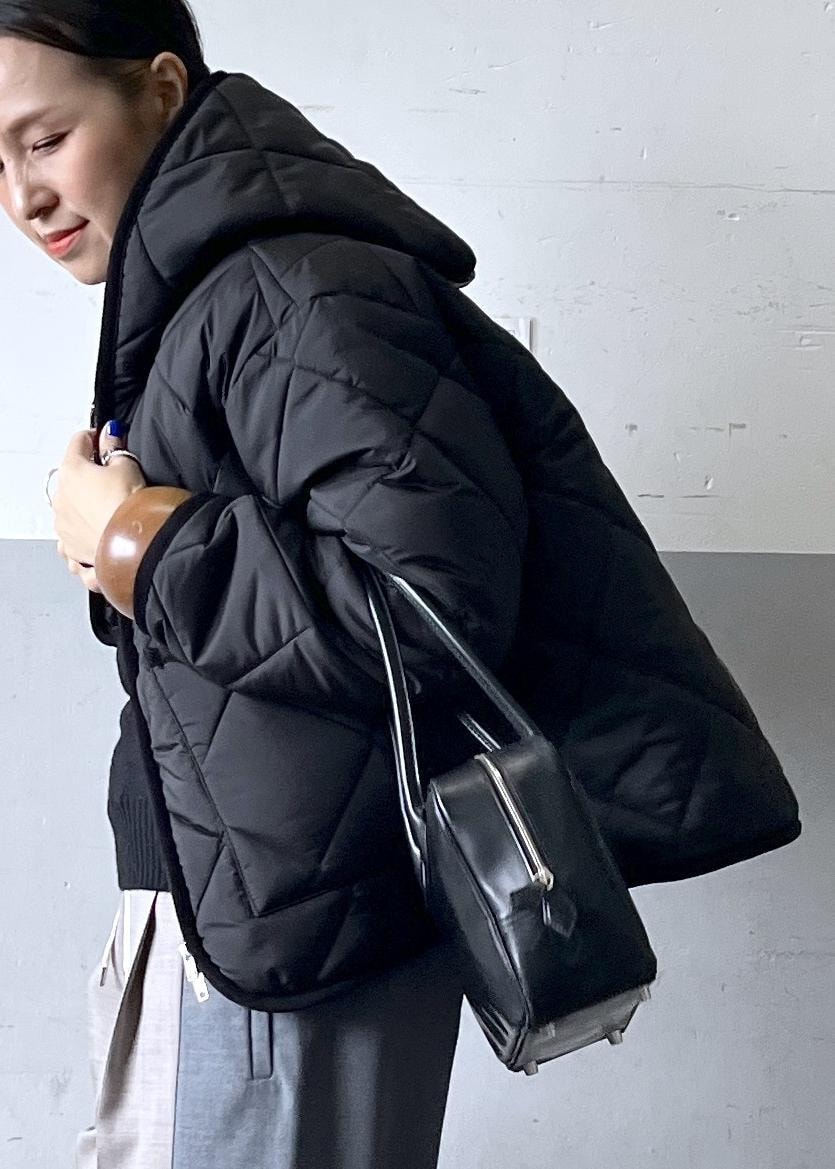 グレー系のその他パンツ、ブラック系のニット/セーター、ホワイト系のスニーカーを着用したレディースの冬コーディネートの7枚目の写真