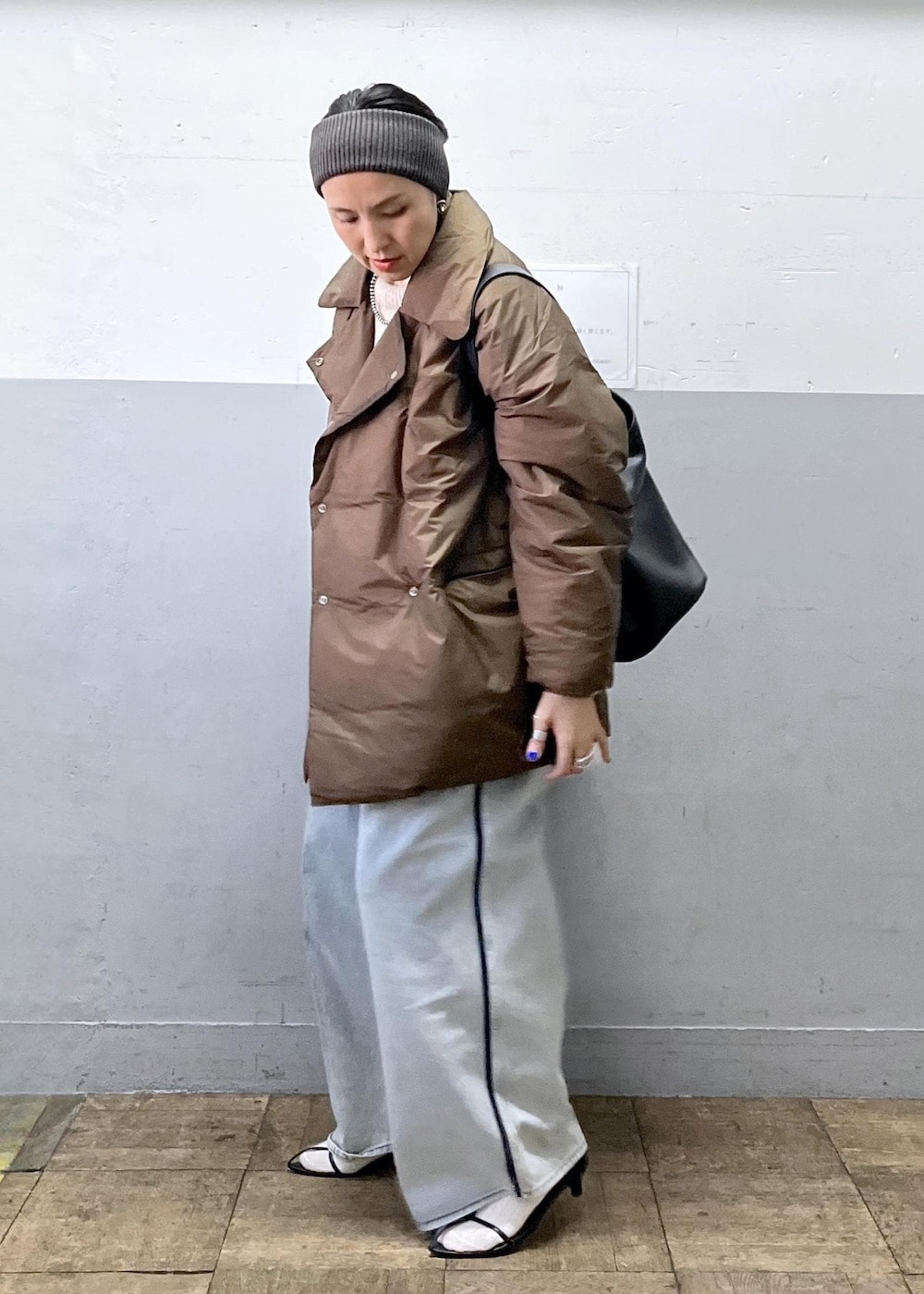 ブルー系のデニムパンツ、ブラック系のショルダーバッグ、ベージュ系のニット/セーターを着用したレディースの冬コーディネートの6枚目の写真