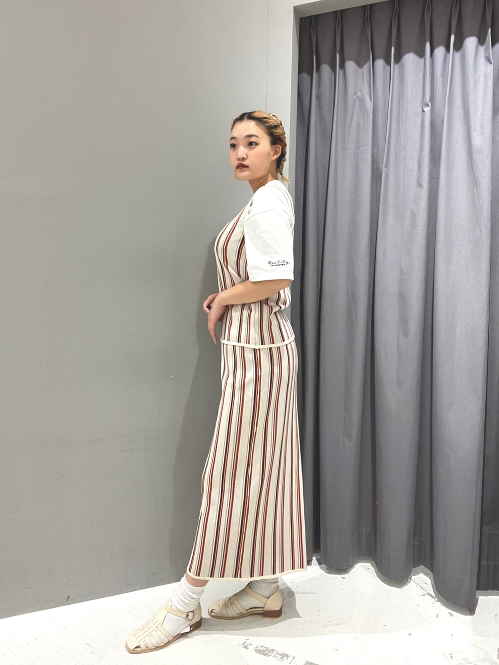 ホワイト系のスカート、ホワイト系のTシャツ/カットソー、ホワイト系のベストを着用したレディースの春コーディネートの2枚目の写真