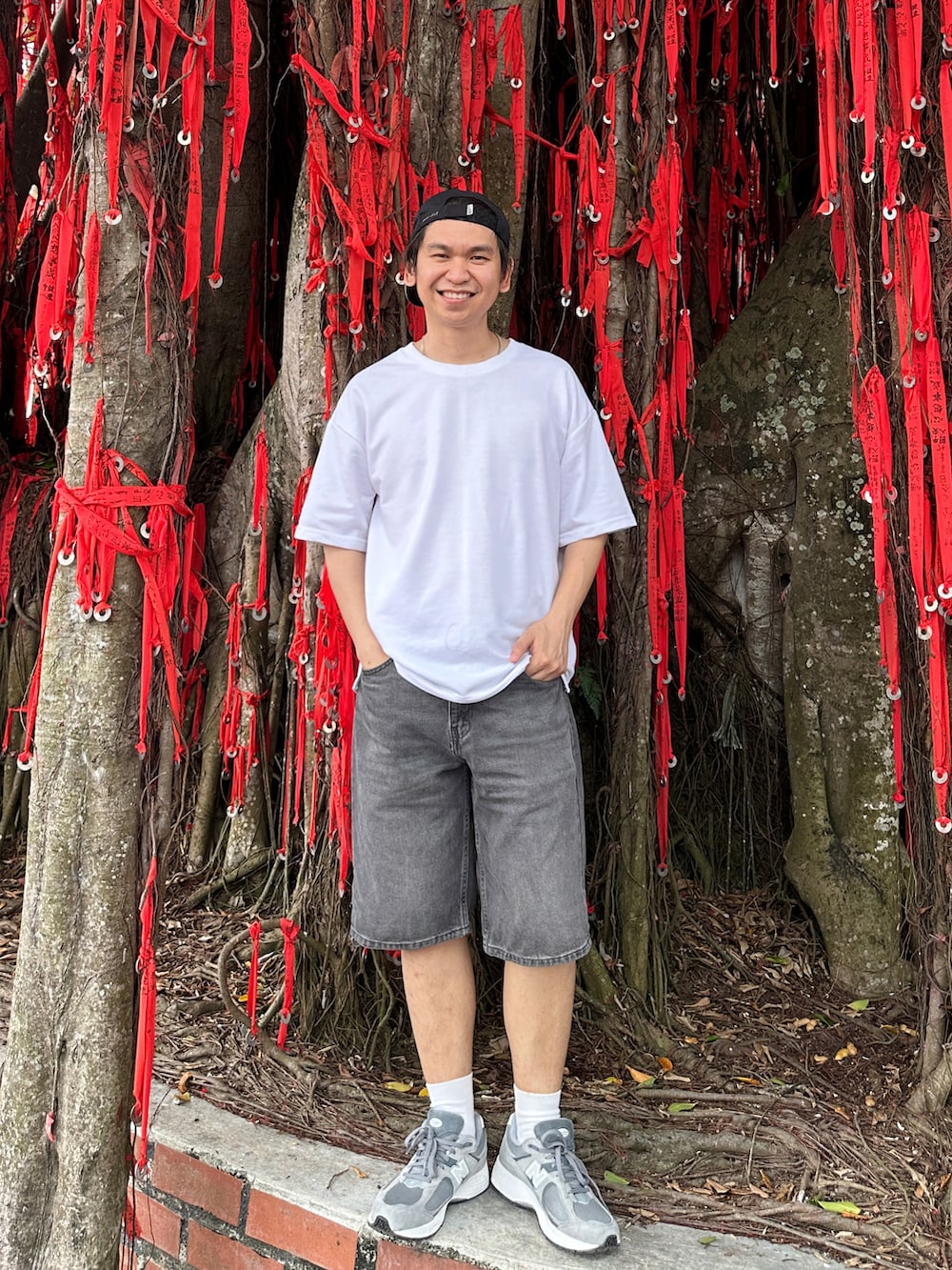 グレー系のスニーカー、グレー系のデニムパンツ、ブラック系のキャップを着用したメンズの夏コーディネートの2枚目の写真