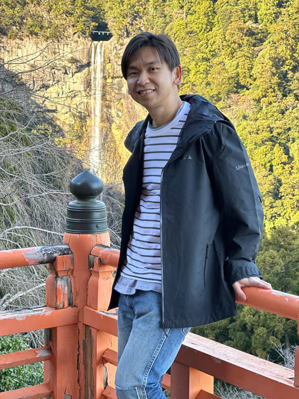 ブラック系のバックパック/リュック、ベージュ系のスニーカー、ブルー系のデニムパンツを着用したメンズの冬コーディネートの3枚目の写真