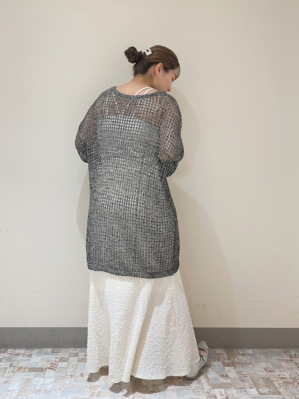 ホワイト系のスカート、ブラック系のニット/セーターを着用したレディースの春コーディネートの3枚目の写真