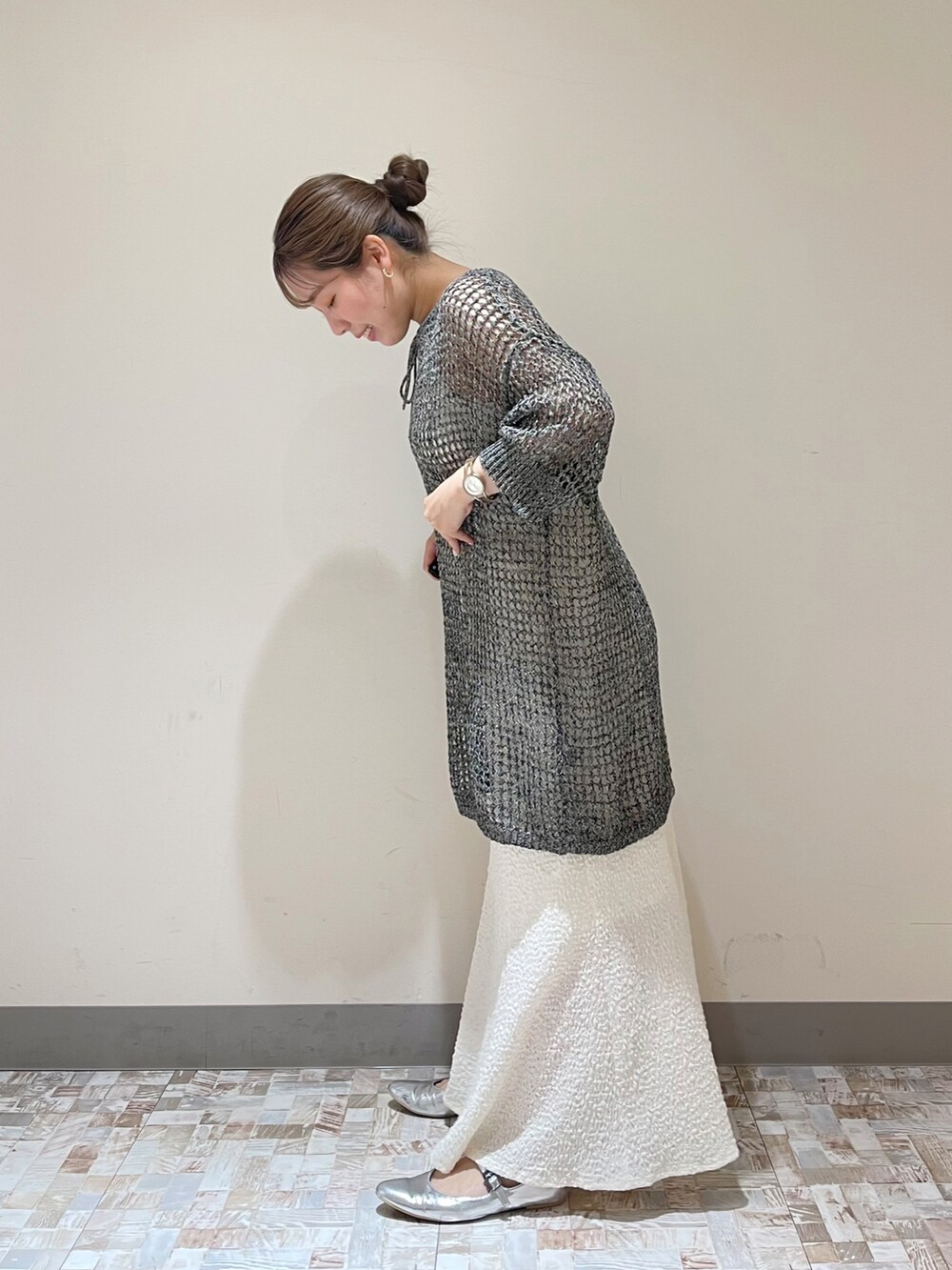 ホワイト系のスカート、ブラック系のニット/セーターを着用したレディースの春コーディネートの2枚目の写真