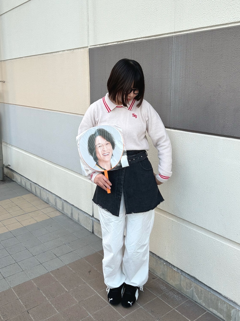 ピンク系のニット/セーター、ホワイト系のカーゴパンツ、ブラック系のスニーカーを着用したレディースの冬コーディネートの2枚目の写真
