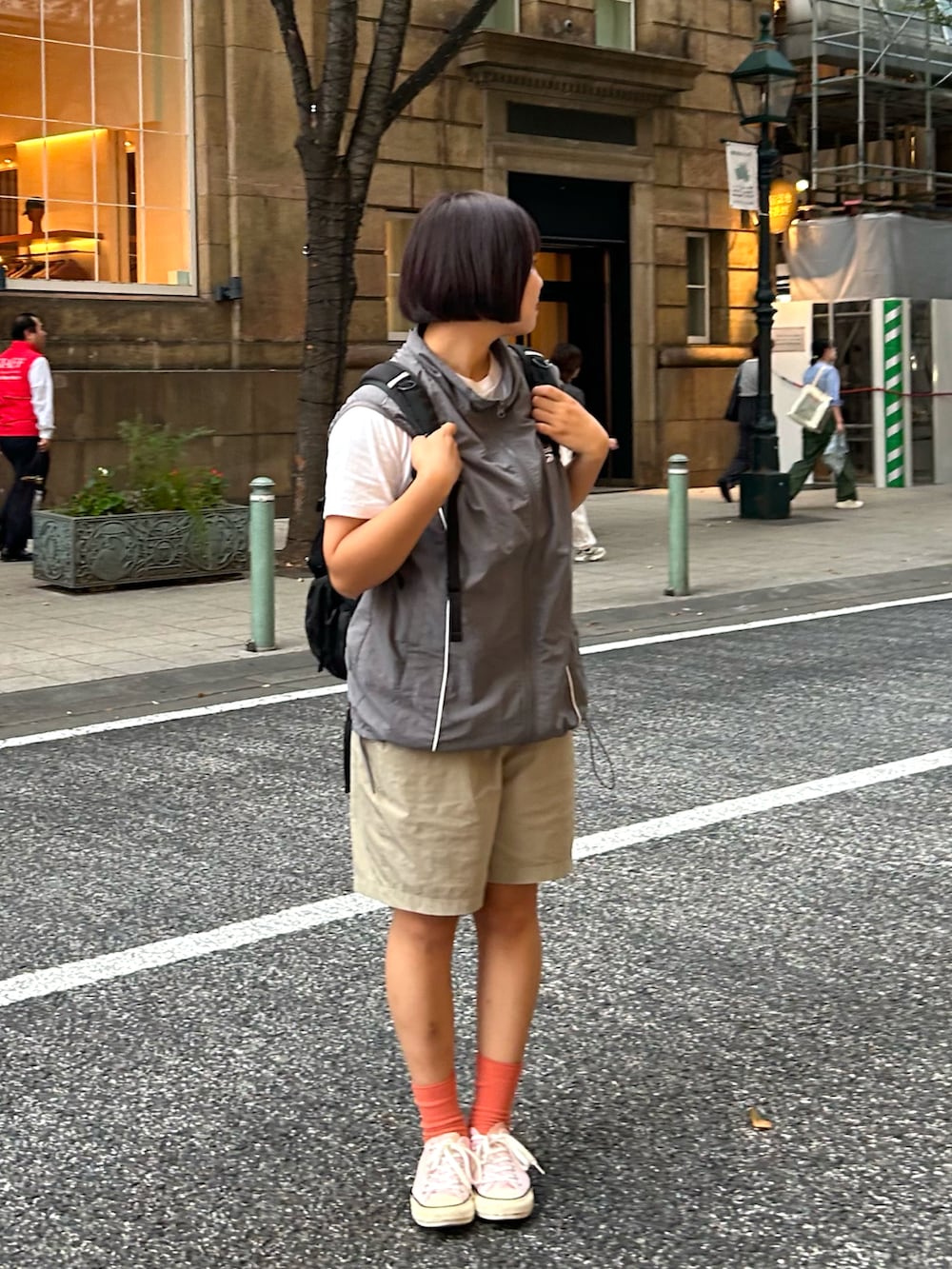 ピンク系のスニーカー、ブラック系のバックパック/リュック、ホワイト系のTシャツ/カットソーを着用したレディースの秋コーディネートの3枚目の写真