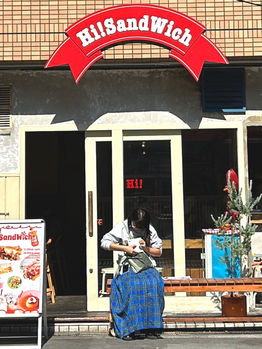 ブルー系のスカート、グレー系のスウェット、グリーン系のトートバッグを着用したレディースの秋コーディネートの3枚目の写真