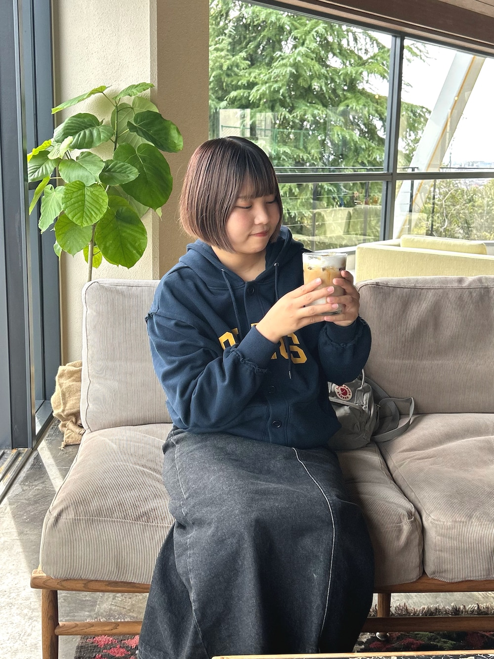 ブルー系のパーカー、ブラック系のデニムスカートを着用したレディースの秋コーディネートの2枚目の写真