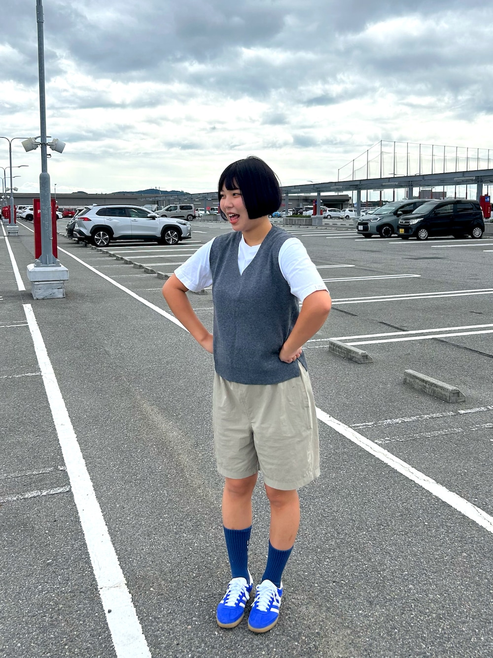 グレー系のベスト、ホワイト系のTシャツ/カットソー、ブルー系のスニーカーを着用したレディースの秋コーディネートの2枚目の写真