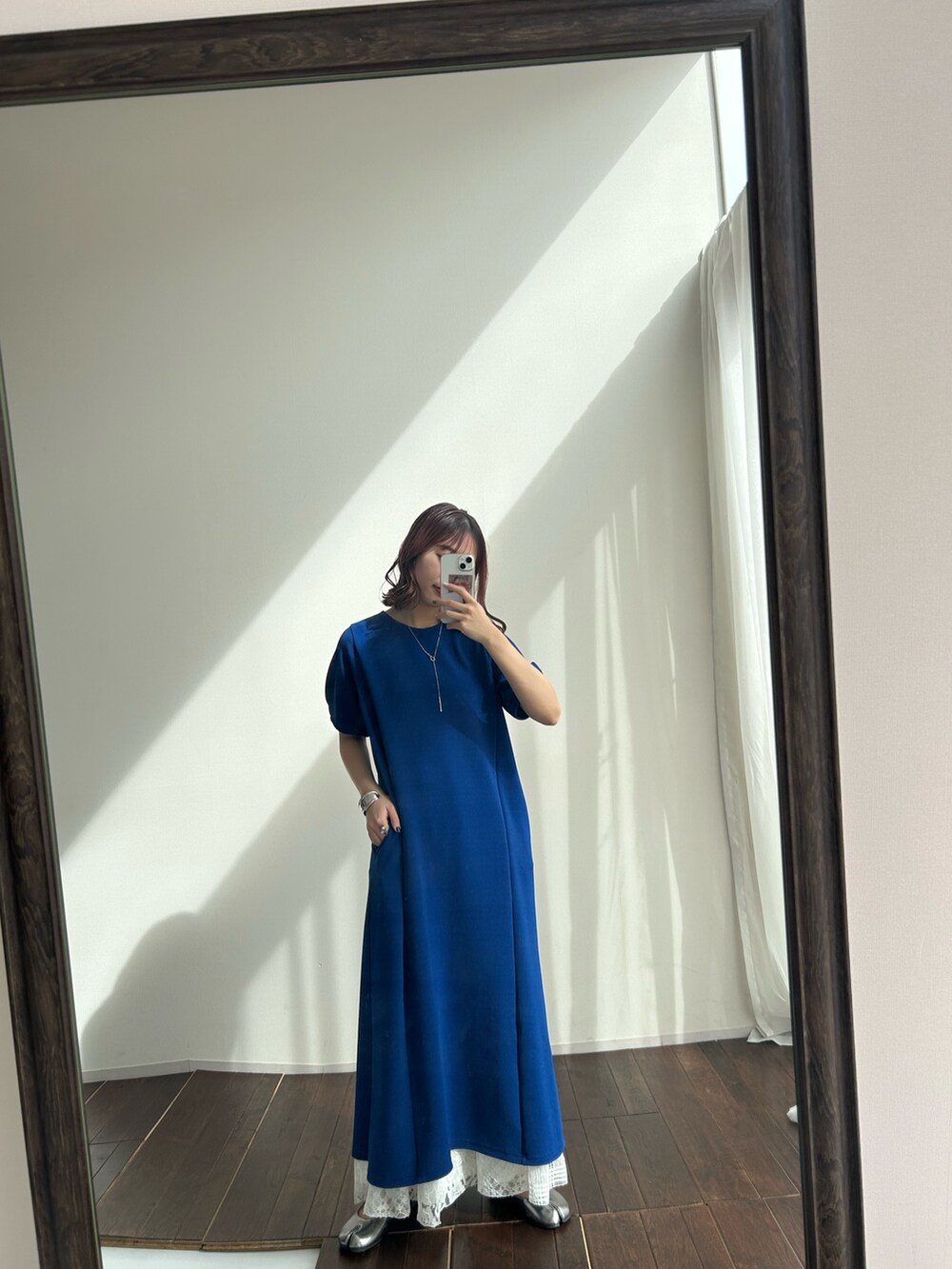 ブルー系のワンピース、ホワイト系のスカートを着用したレディースの春コーディネートの3枚目の写真