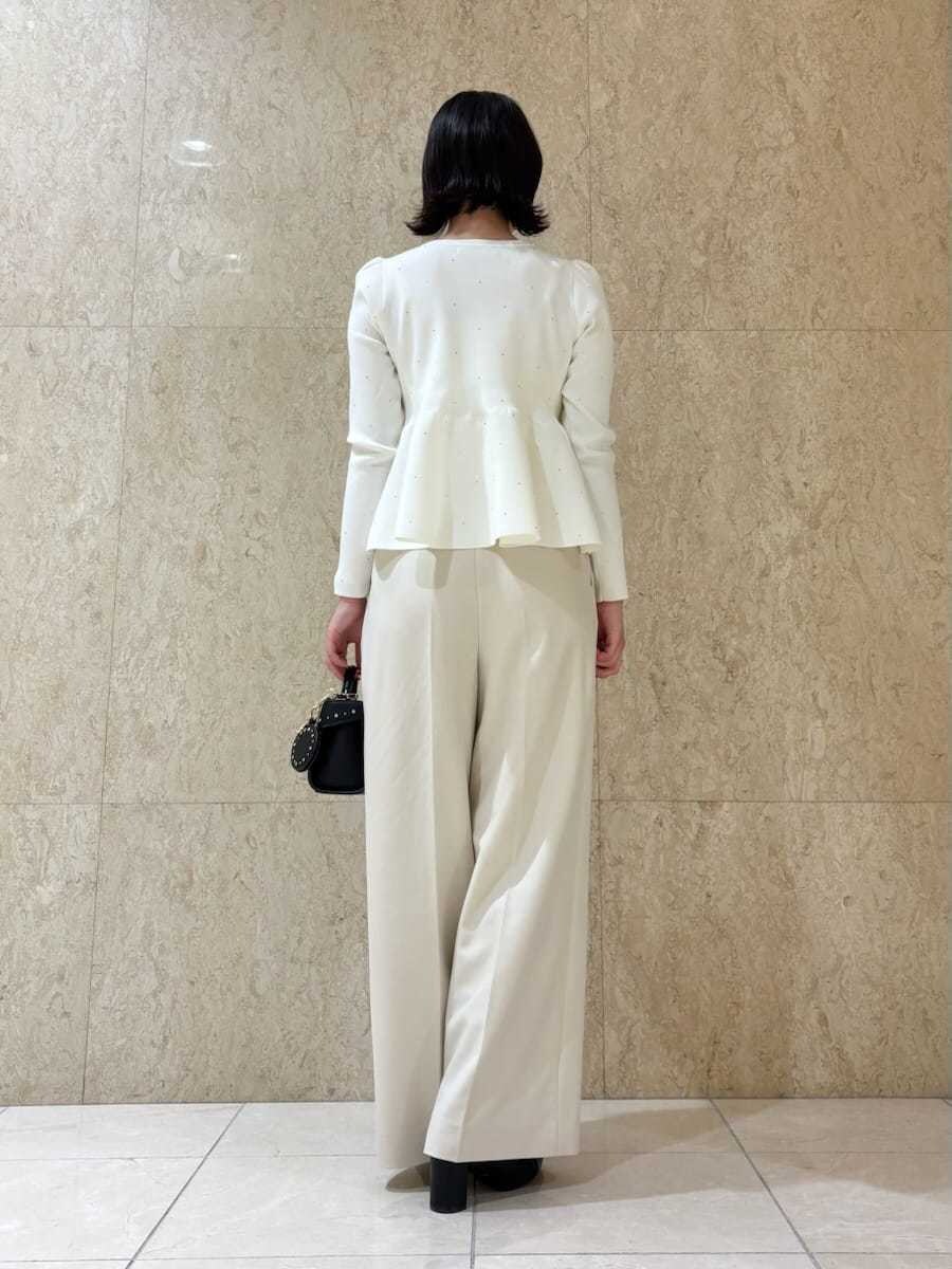 ブラック系のショルダーバッグ、ホワイト系のニット/セーター、ブラック系のキーケース/キーアクセサリーを着用したレディースの秋コーディネートの3枚目の写真