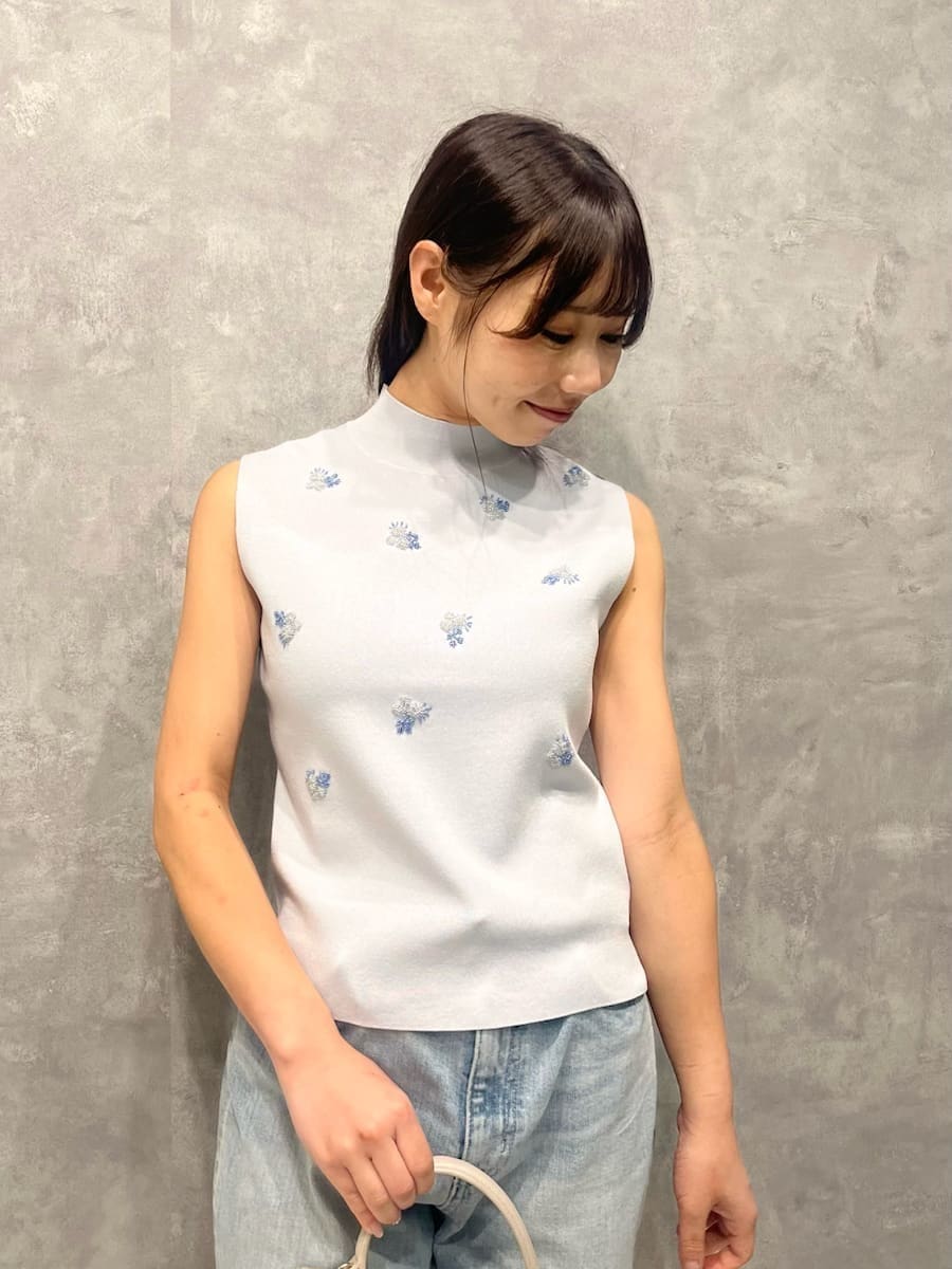 ベージュ系のショルダーバッグ、ブルー系のニット/セーターを着用したレディースの夏コーディネートの4枚目の写真