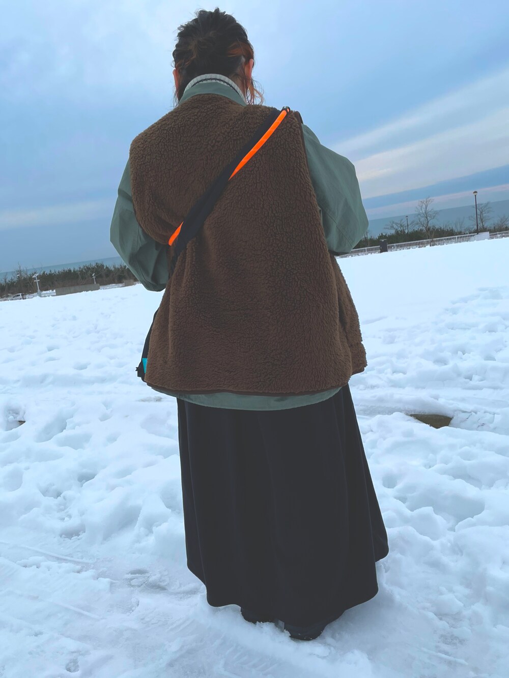 ブラック系のジャンパースカート、ブラウン系のジャケット/アウター、グリーン系のジャケット/アウターを着用したレディースの冬コーディネートの3枚目の写真