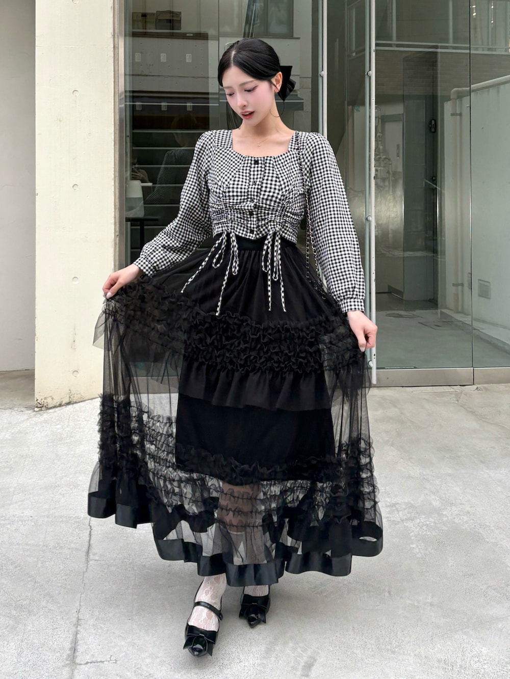 ブラック系のシャツ/ブラウス、ブラック系のスカート、ブラック系のショルダーバッグを着用したレディースの春コーディネートの2枚目の写真