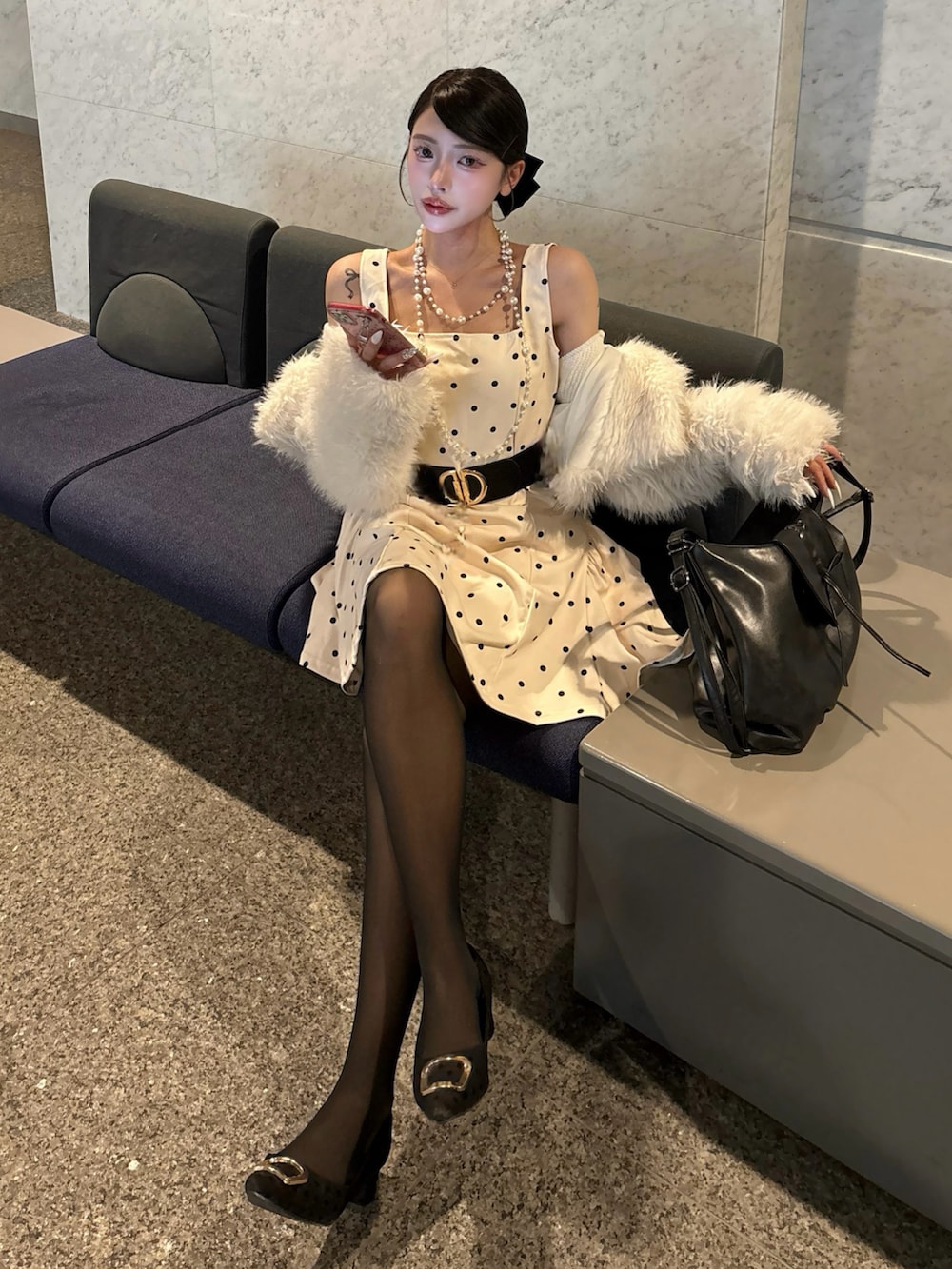 ホワイト系のワンピース、ブラック系のショルダーバッグを着用したレディースの春コーディネートの2枚目の写真