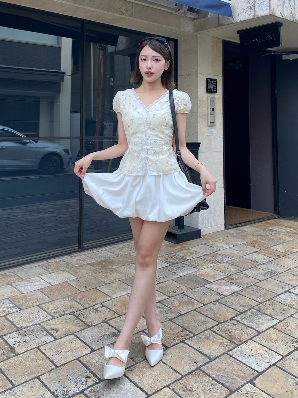 ホワイト系のシャツ/ブラウス、ホワイト系のスカート、ホワイト系のサンダルを着用したレディースの夏コーディネートの3枚目の写真