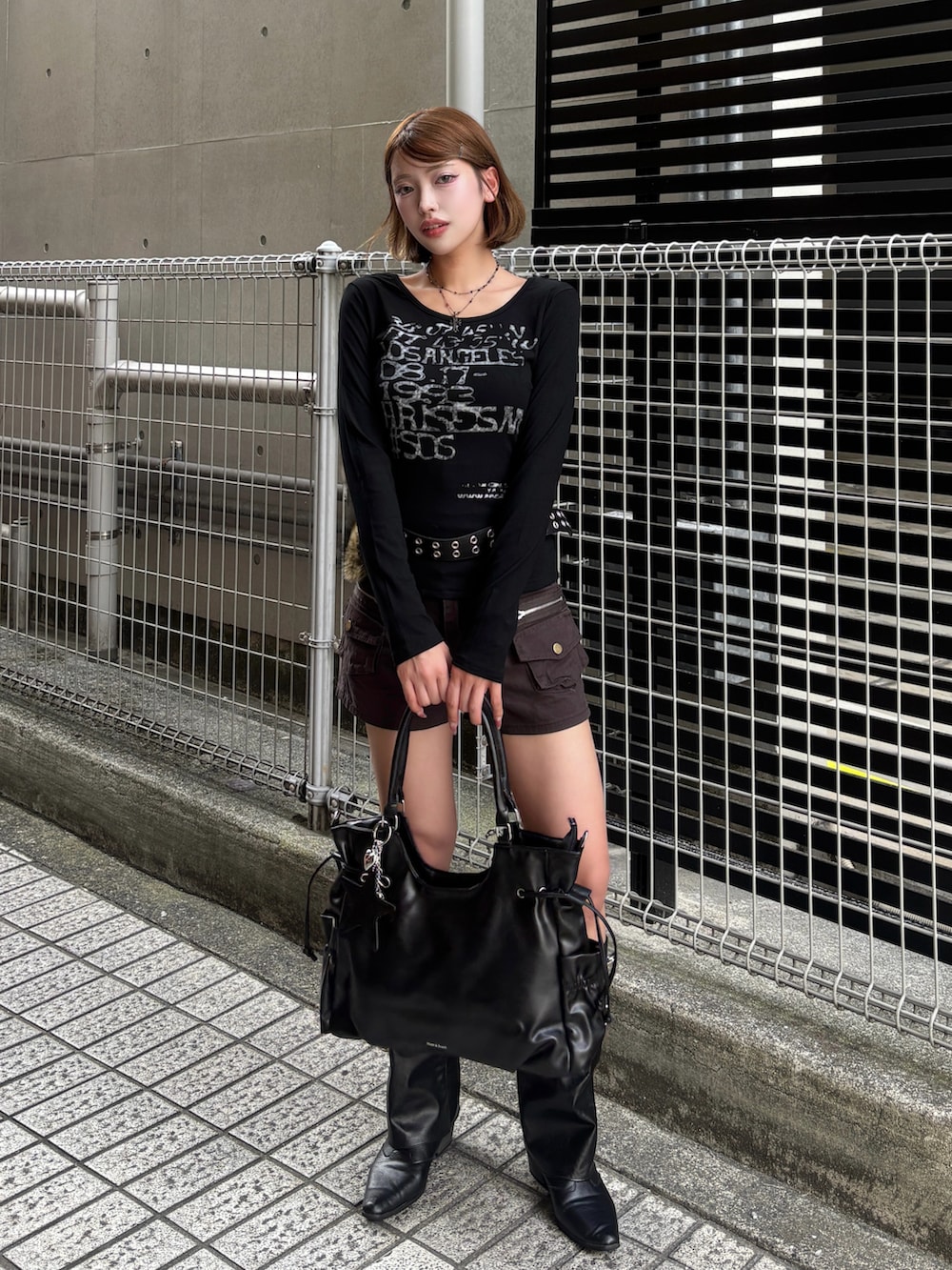 ブラック系のTシャツ/カットソー、ブラック系のトートバッグ、ブラック系のブーツを着用したレディースの秋コーディネートの2枚目の写真