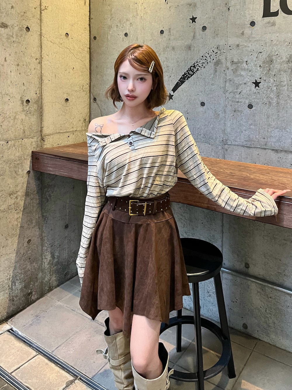 ブラウン系のTシャツ/カットソー、ベージュ系のブーツ、ブラウン系のスカートを着用したレディースの秋コーディネートの3枚目の写真