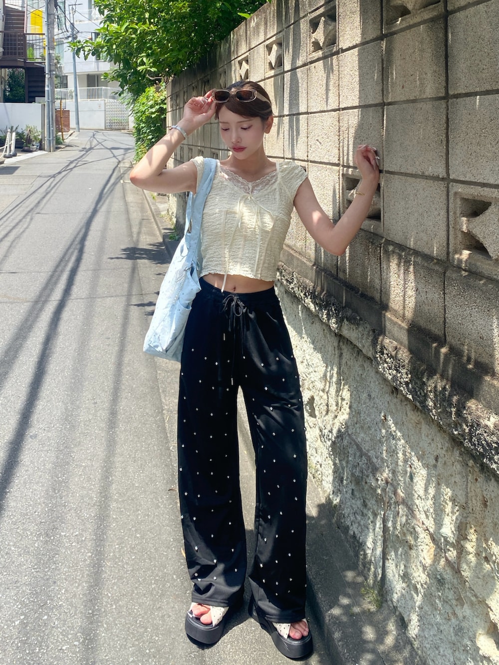 ブルー系のトートバッグを着用したレディースの夏コーディネートの2枚目の写真