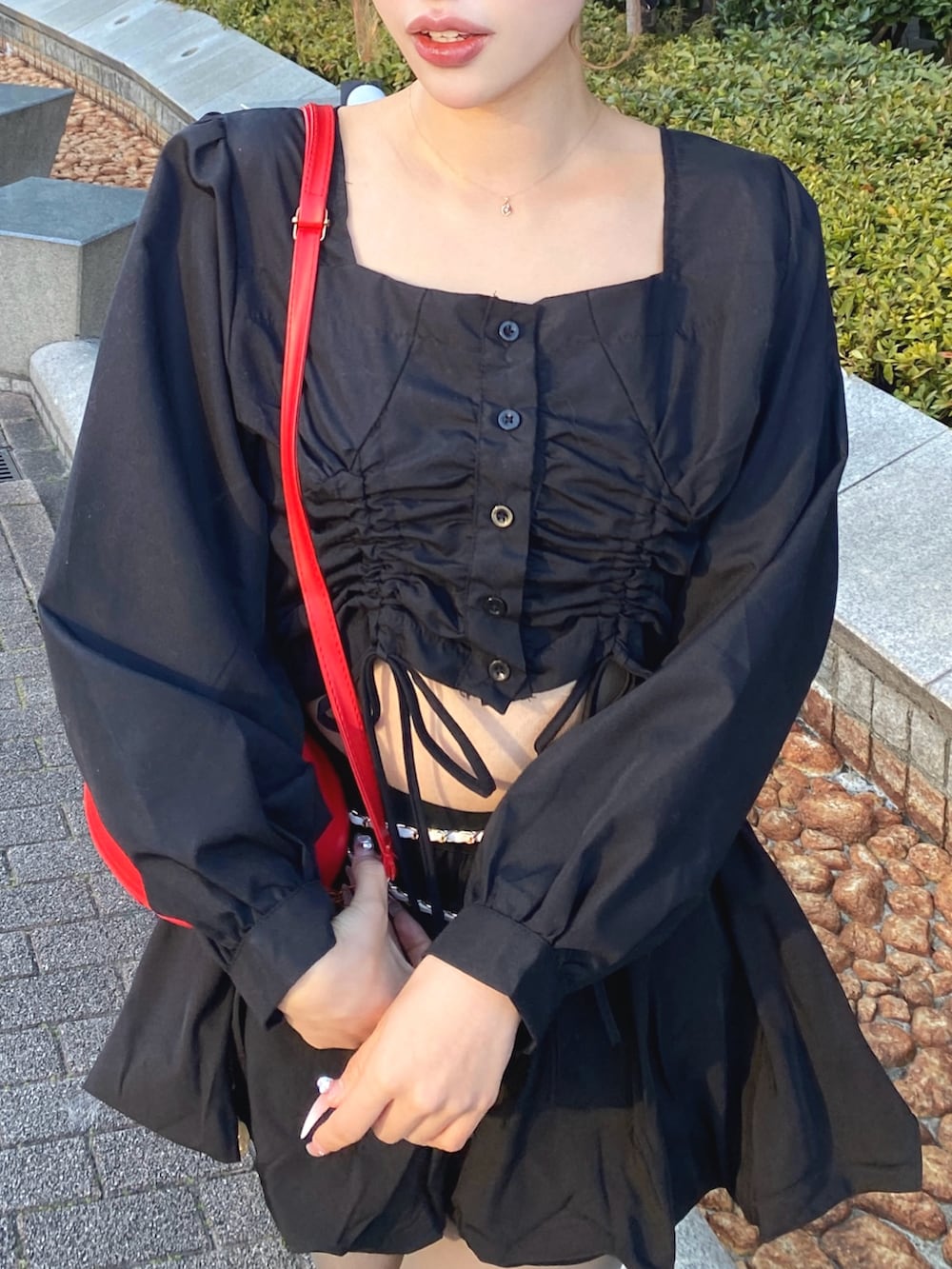 ブラック系のシャツ/ブラウス、ブラック系のスカート、レッド系のショルダーバッグを着用したレディースの冬コーディネートの3枚目の写真