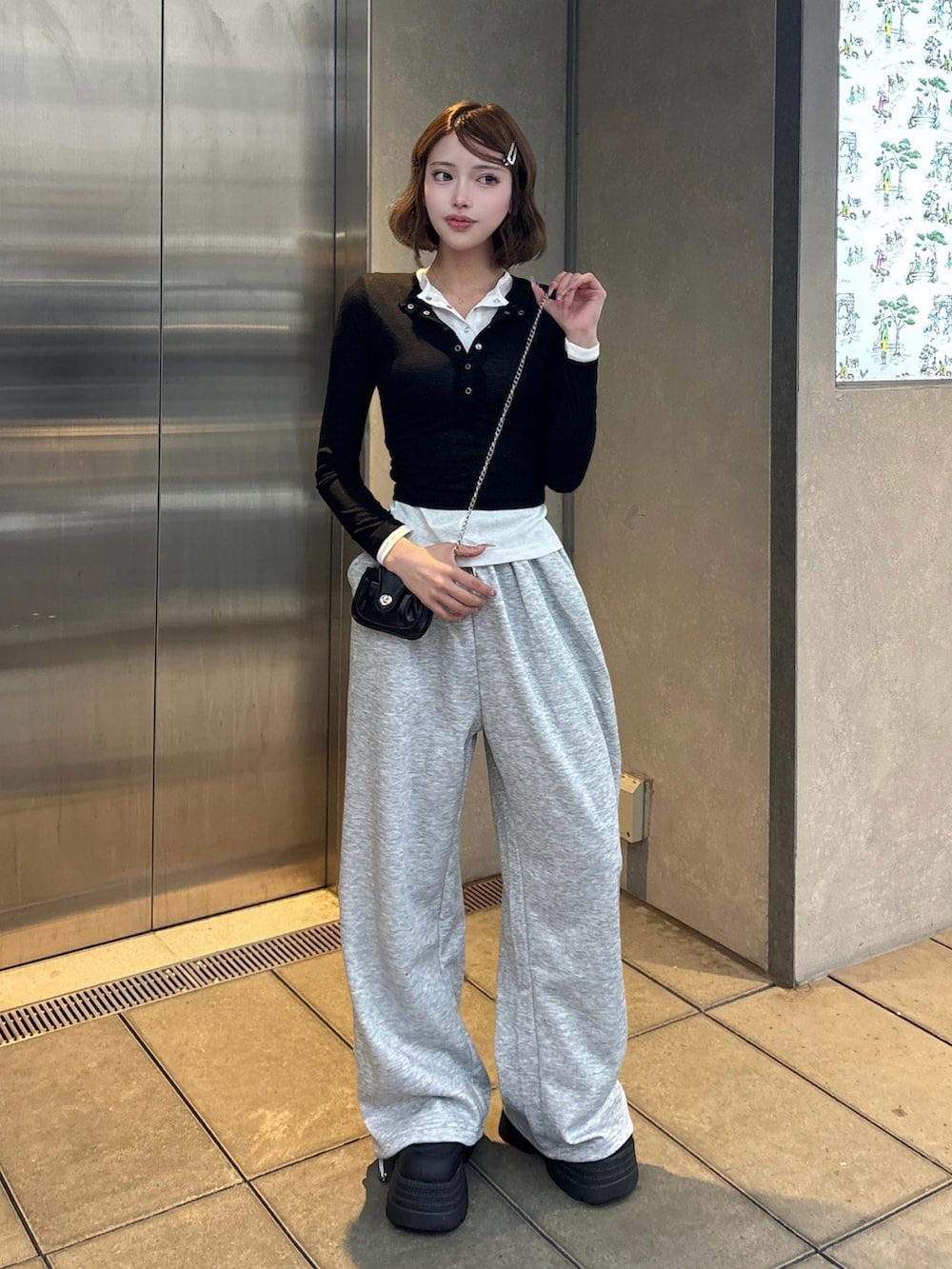 ブラック系のTシャツ/カットソー、グレー系のスウェットパンツ、ブラック系のスニーカーを着用したレディースの秋コーディネートの2枚目の写真