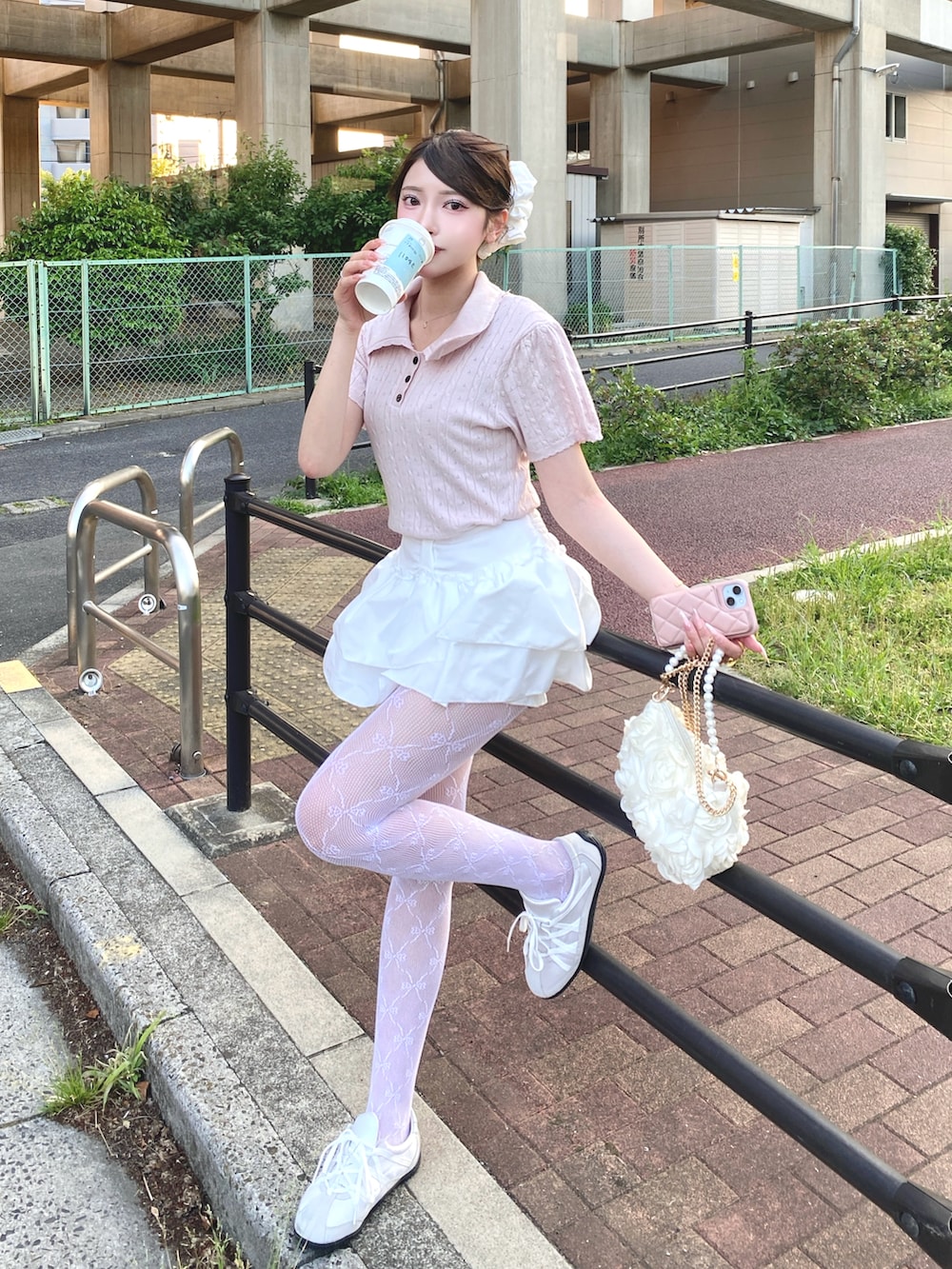 ピンク系のポロシャツ、ホワイト系のスカート、ホワイト系のタイツ/ストッキングを着用したレディースの夏コーディネートの3枚目の写真