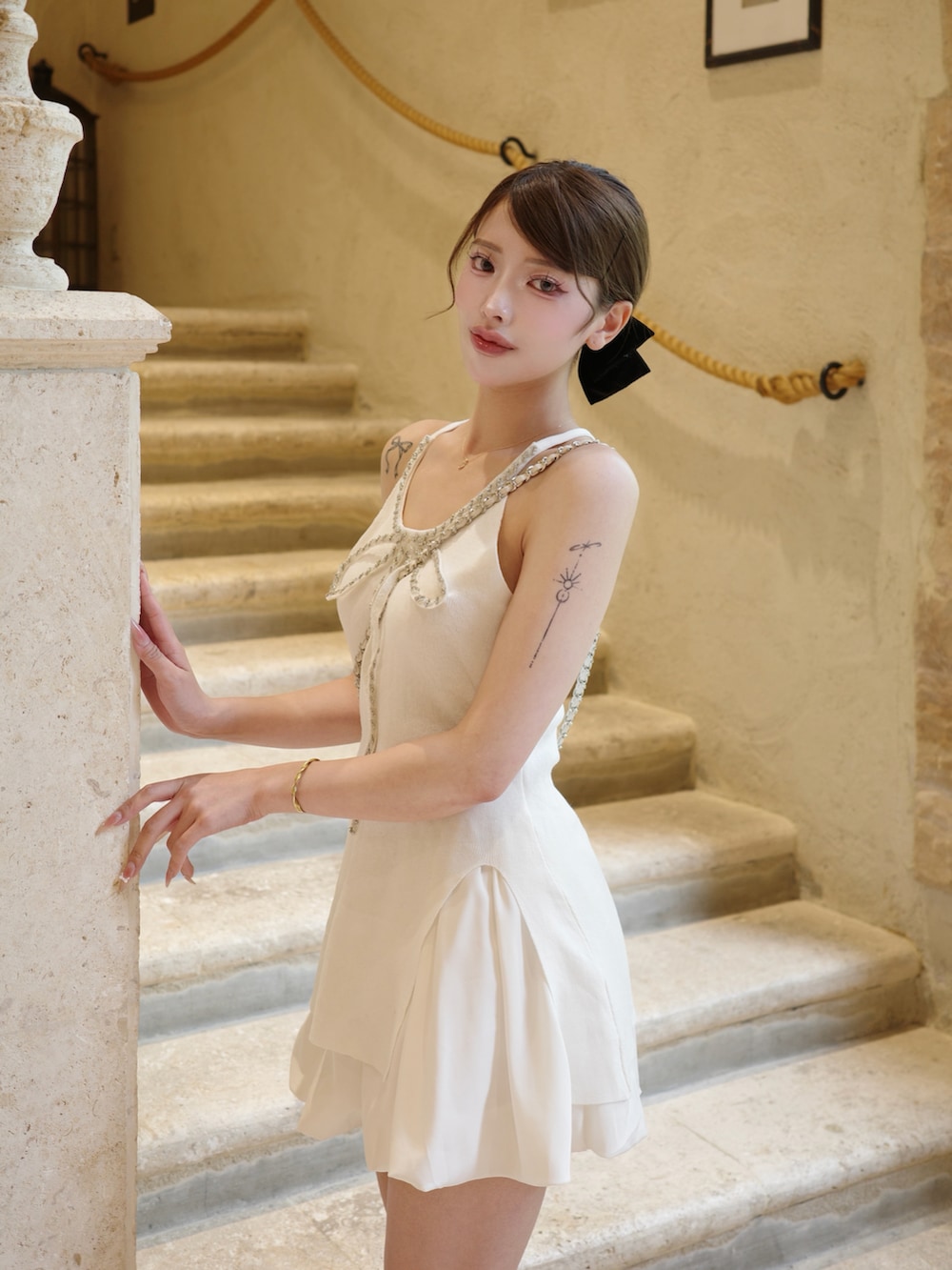 ホワイト系のスカート、ホワイト系のチュニック、ブラック系のパンプスを着用したレディースの夏コーディネートの2枚目の写真