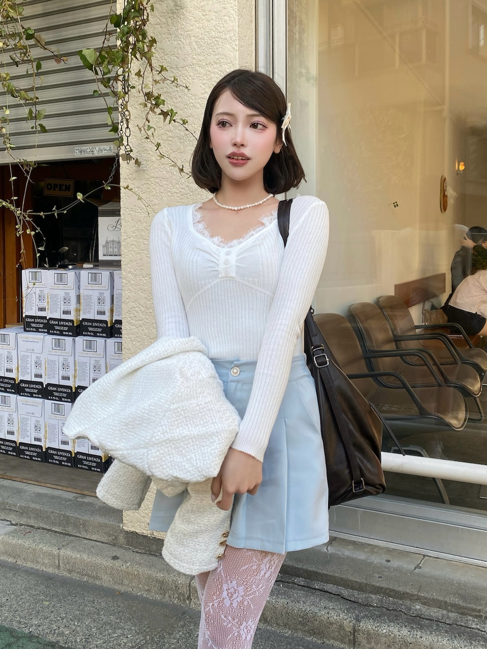 ホワイト系のニット/セーター、ホワイト系のその他アウター、ブルー系のその他パンツを着用したレディースの春コーディネートの3枚目の写真