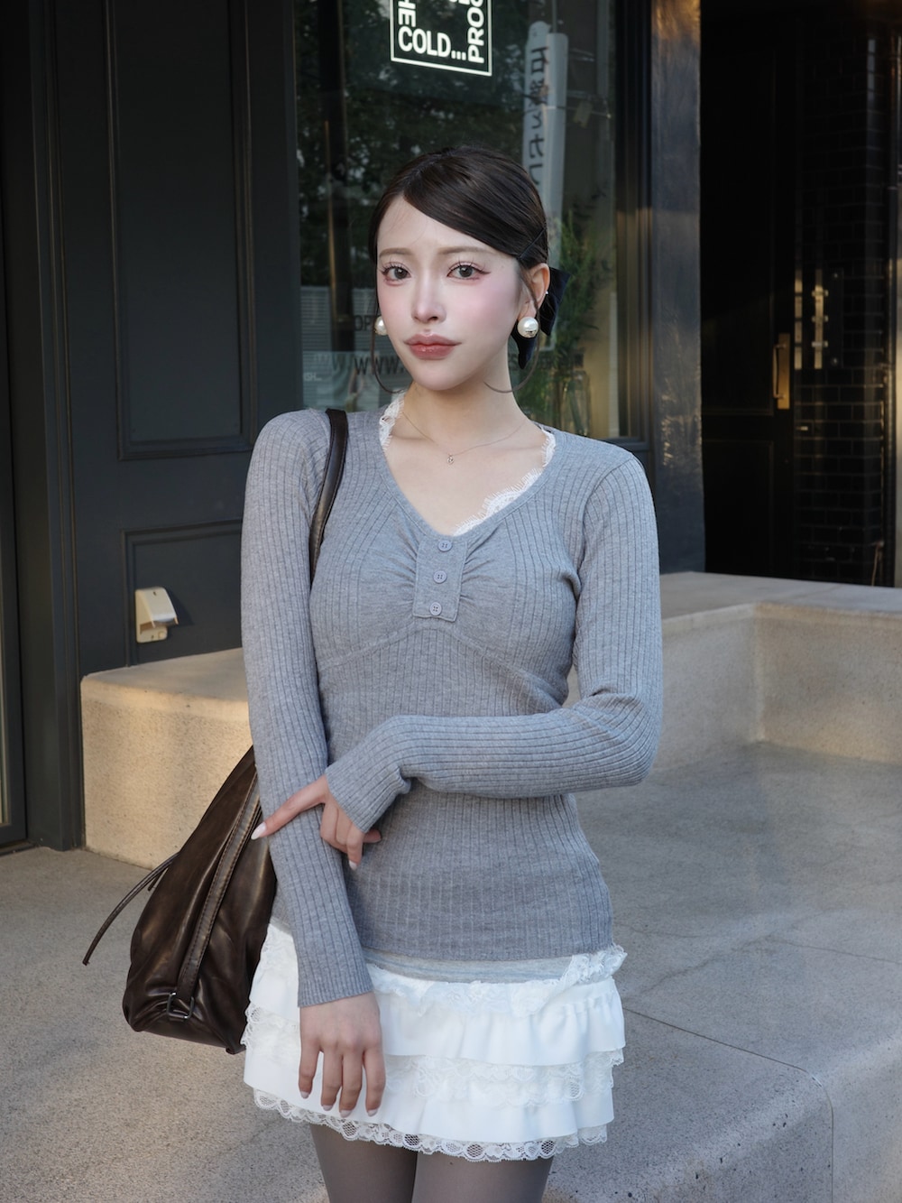 グレー系のニット/セーター、ブラウン系のショルダーバッグを着用したレディースの冬コーディネートの3枚目の写真