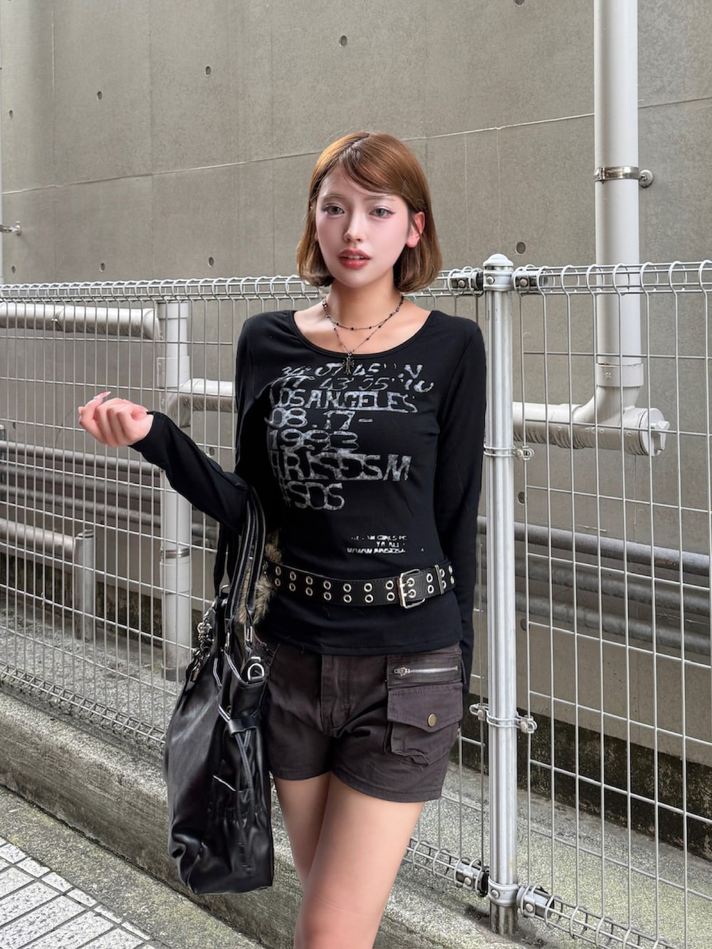 ブラック系のTシャツ/カットソー、ブラック系のトートバッグ、ブラック系のブーツを着用したレディースの秋コーディネートの3枚目の写真
