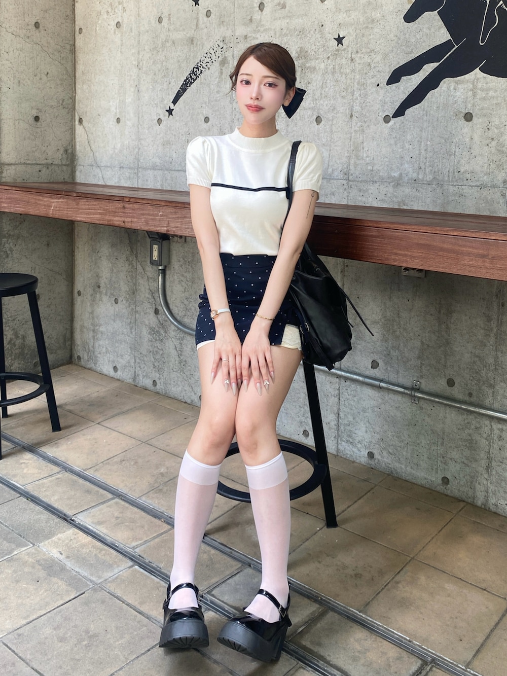 ブラック系のショルダーバッグを着用したレディースの夏コーディネートの2枚目の写真