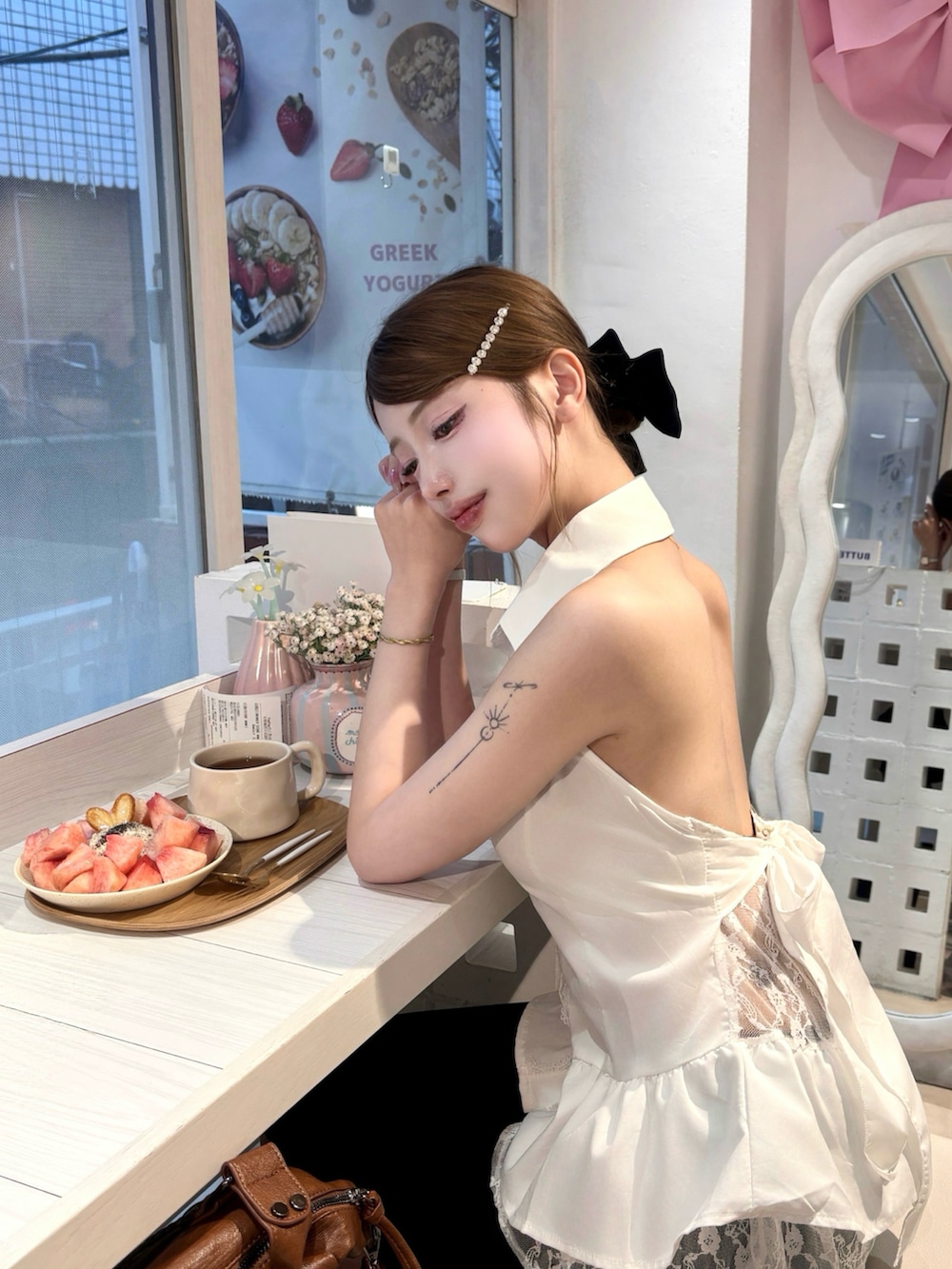 ホワイト系のシャツ/ブラウス、ブラック系のショルダーバッグを着用したレディースの夏コーディネートの3枚目の写真