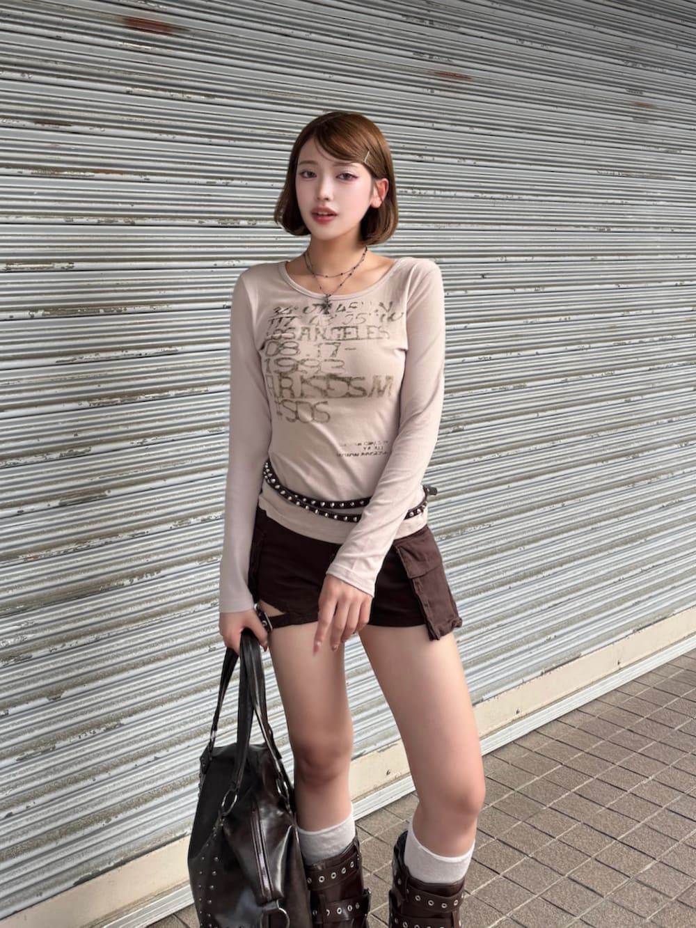 ベージュ系のTシャツ/カットソー、ブラウン系のデニムパンツ、ブラウン系のブーツを着用したレディースの秋コーディネートの3枚目の写真