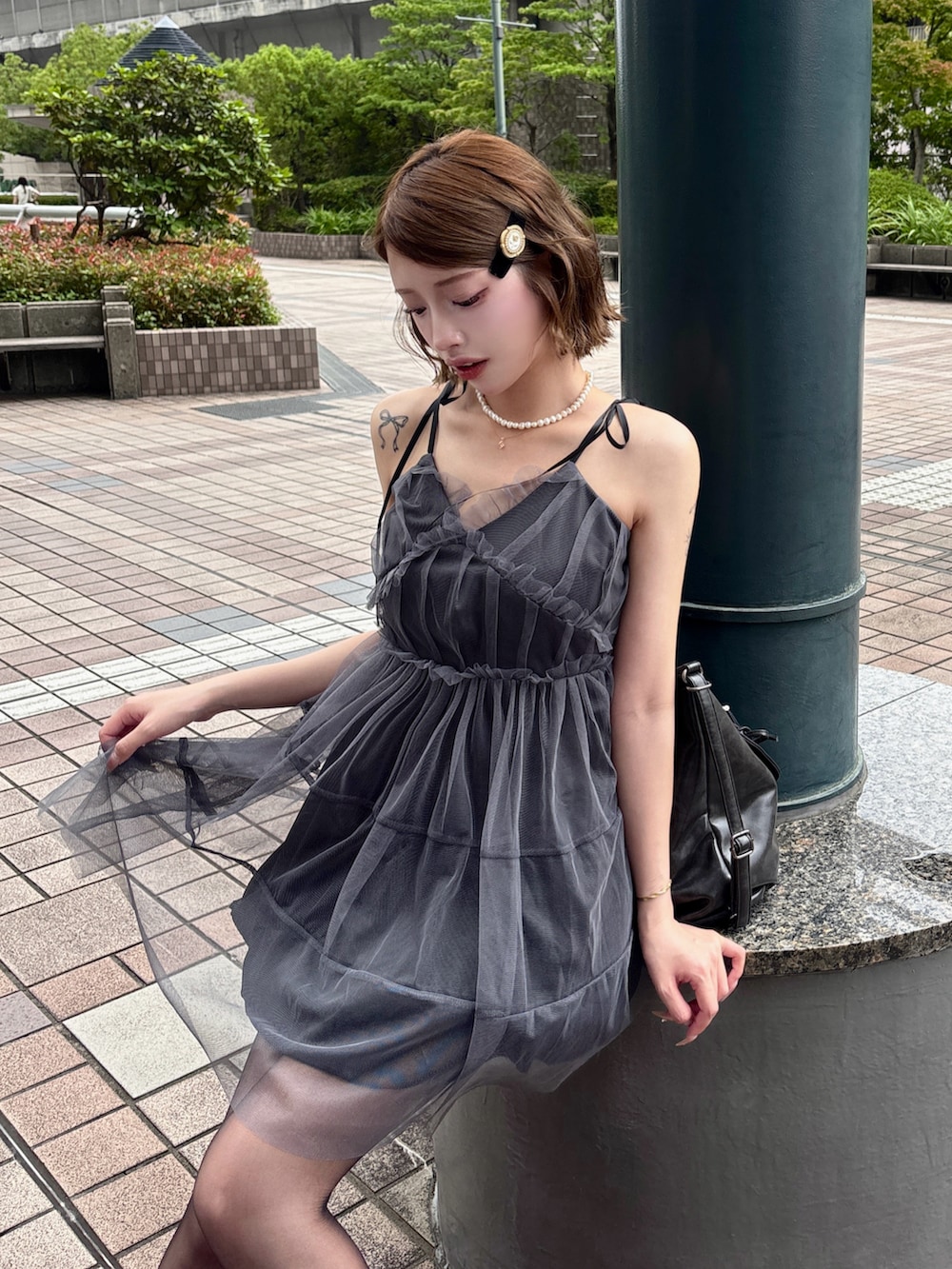 グレー系のワンピース、ブラック系のショルダーバッグを着用したレディースの夏コーディネートの3枚目の写真