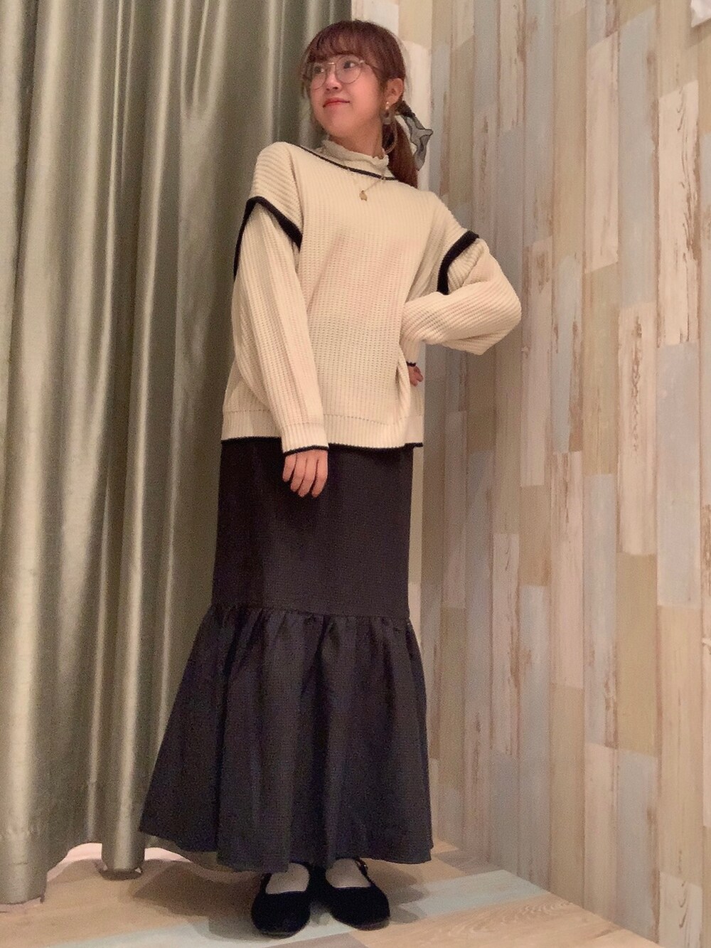 グレー系のスカート、ホワイト系のニット/セーターを着用したレディースの冬コーディネートの2枚目の写真